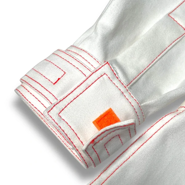detalle de la manga de la sobrecamisa los cachelos de color blanco-off con costuras rojas de ferdy ferdystreetwear
